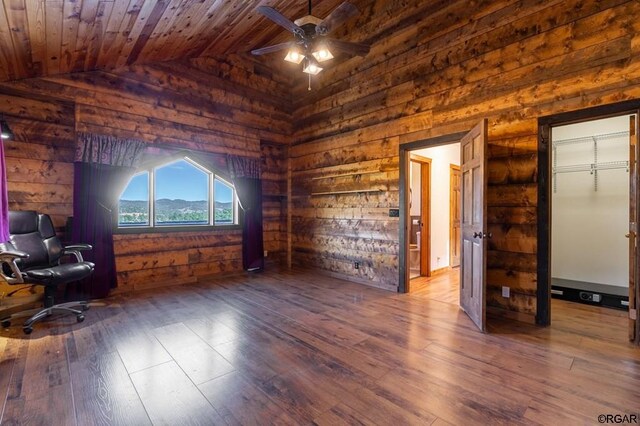 unfurnished office featuring lofted ceiling, wood walls, wooden ceiling, hardwood / wood-style flooring, and ceiling fan