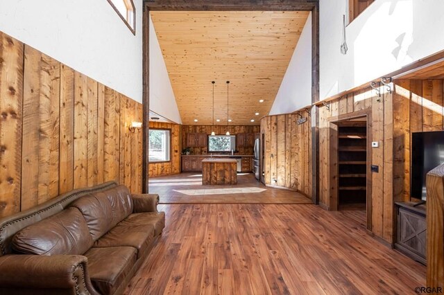 unfurnished living room with dark hardwood / wood-style flooring, wooden walls, wood ceiling, and high vaulted ceiling