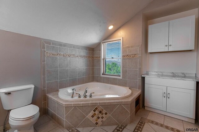 bathroom with lofted ceiling, tile patterned flooring, a relaxing tiled tub, and toilet