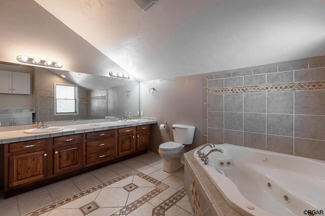 bathroom with lofted ceiling, tile patterned flooring, vanity, tiled bath, and toilet