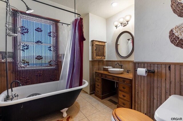 bathroom with tile patterned flooring, toilet, vanity, and wood walls