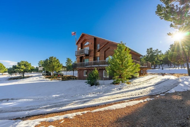 snow covered property featuring a balcony