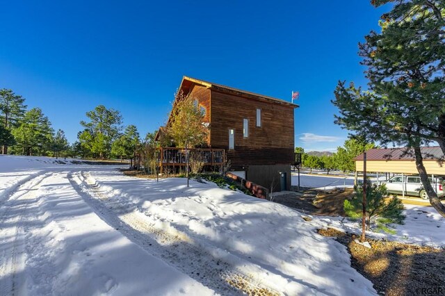 view of snowy exterior with a deck