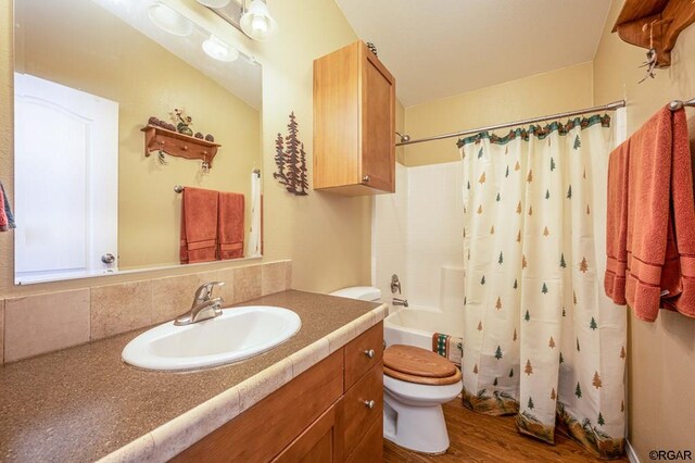 full bathroom with toilet, tasteful backsplash, vanity, shower / bath combo with shower curtain, and hardwood / wood-style floors