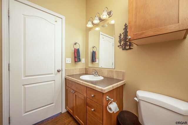 bathroom featuring vanity, hardwood / wood-style floors, and toilet