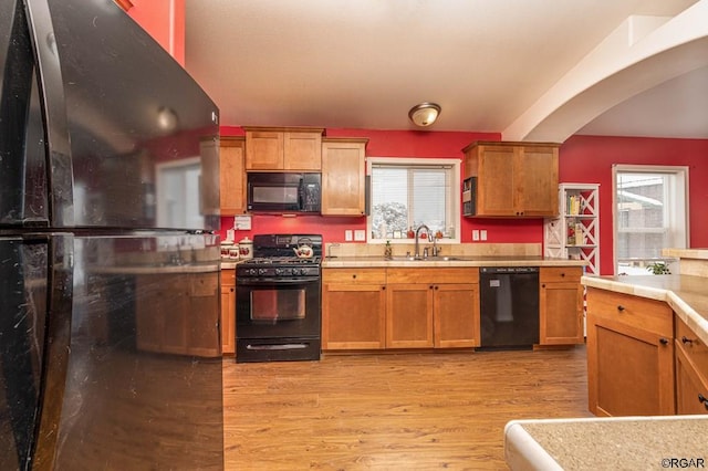 kitchen featuring sink, black appliances, and light wood-type flooring