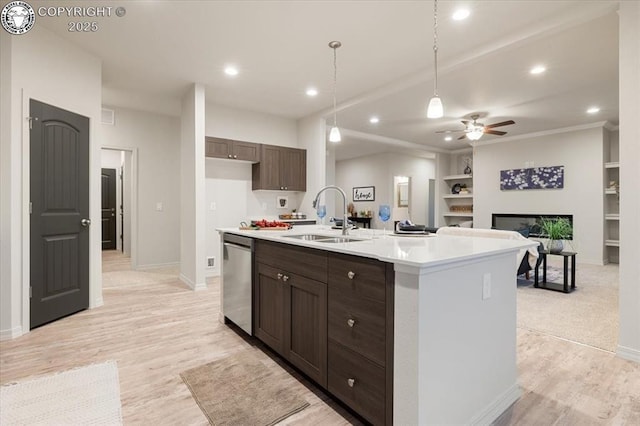 kitchen featuring a kitchen island with sink, sink, dark brown cabinets, and stainless steel dishwasher