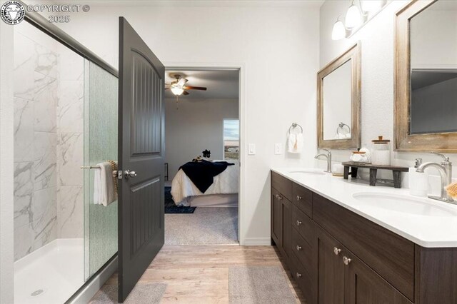 bathroom featuring walk in shower, ceiling fan, wood-type flooring, and vanity