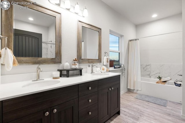 bathroom featuring hardwood / wood-style flooring, vanity, and shower / tub combo