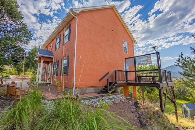 view of side of home with a deck with mountain view