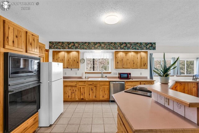 161 Shannon Rd, Cotopaxi, CO 81223 - kitchen featuring black appliances, a textured ceiling, light countertops, healthy amount of natural light, and light tile patterned floors