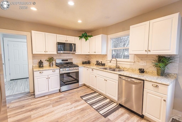121 W Evans Ave, Pueblo, CO 81004 - kitchen with white cabinetry, light wood finished floors, stainless steel appliances, and a sink