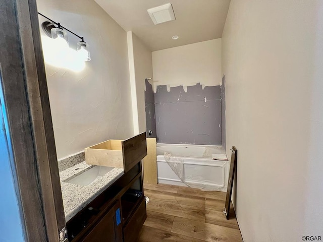 bathroom with vanity, hardwood / wood-style flooring, and a bathing tub