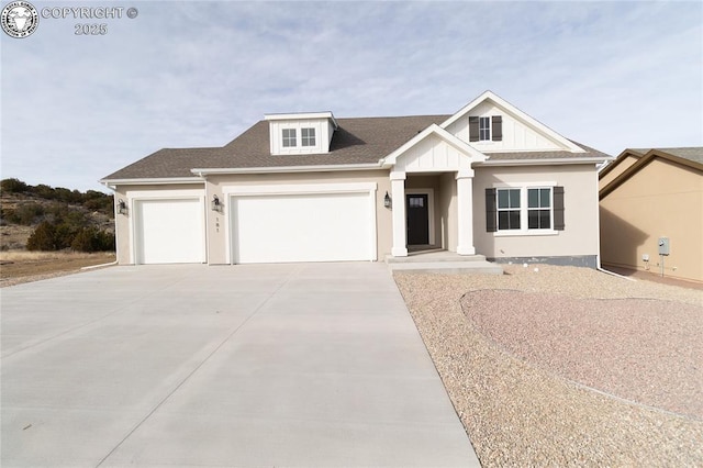 view of front of house with board and batten siding, a garage, driveway, and a shingled roof