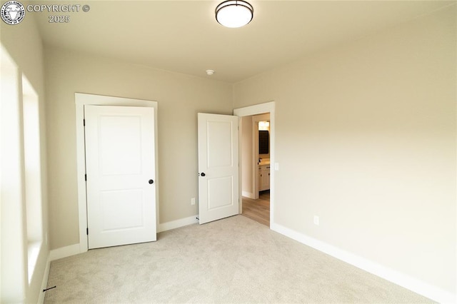 unfurnished bedroom featuring light carpet and baseboards