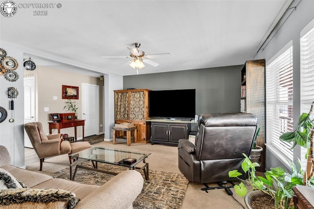 carpeted living room with ceiling fan