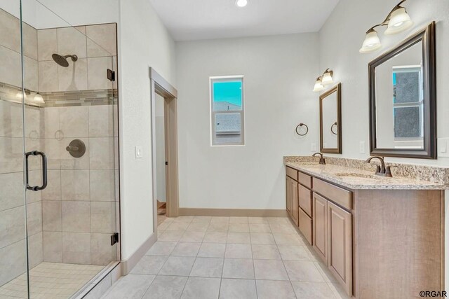 bathroom featuring tile patterned flooring, vanity, and a shower with door