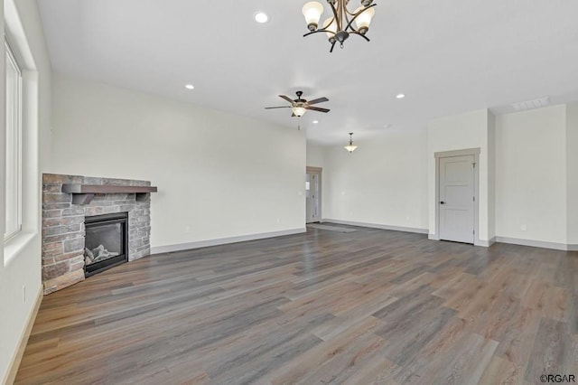 117 Rocchio Dr, Florence, CO 81226 - unfurnished living room with recessed lighting, ceiling fan with notable chandelier, a stone fireplace, and wood finished floors