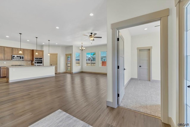 117 Rocchio Dr, Florence, CO 81226 - unfurnished living room with ceiling fan with notable chandelier, wood finished floors, baseboards, and recessed lighting