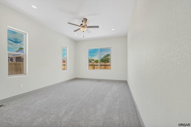 carpeted spare room featuring ceiling fan