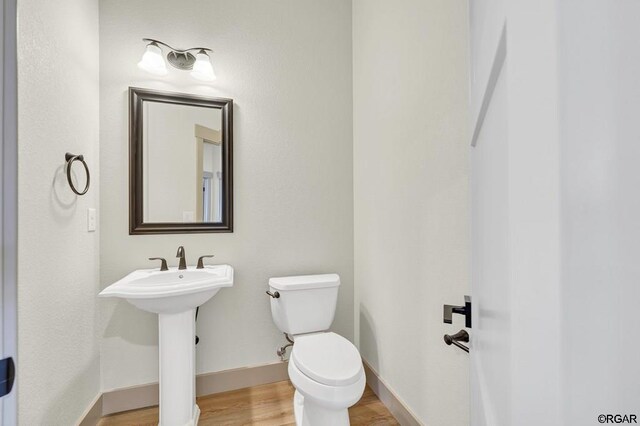 bathroom with wood-type flooring and toilet