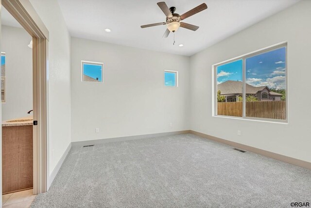 carpeted empty room featuring ceiling fan