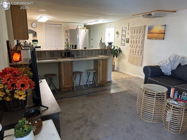 600 Raintree Blvd Unit 76, Canon City, CO 81212 - kitchen featuring stainless steel fridge with ice dispenser, a kitchen bar, a peninsula, and carpet floors