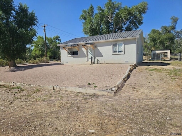 back of house with crawl space, metal roof, stucco siding, and a standing seam roof