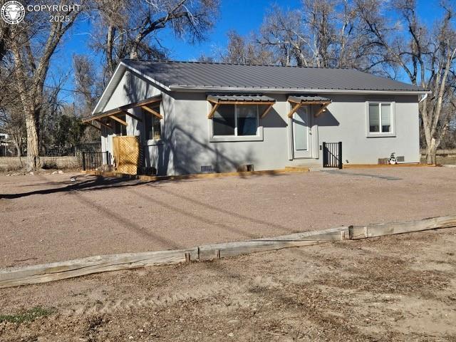 760 D St, Penrose, CO 81240 - view of front of house with crawl space, stucco siding, and metal roof