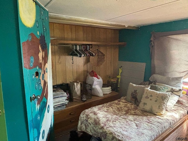 bedroom featuring a closet and wood walls