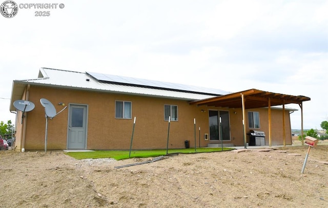 2794 Elizabeth St, Canon City, CO 81212 - back of property with solar panels, stucco siding, and a metal roof