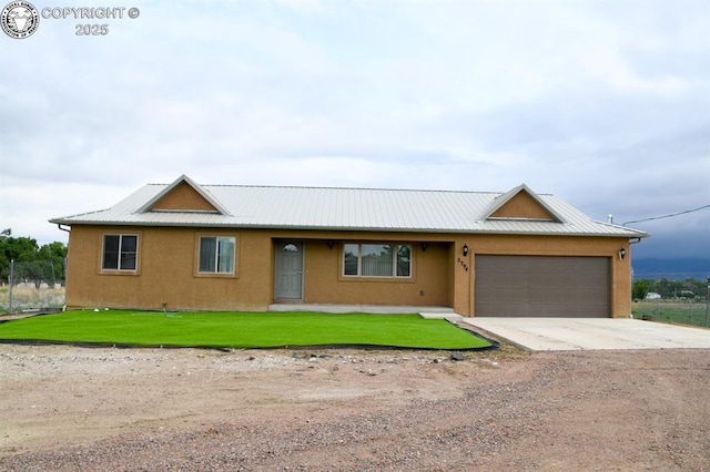 2794 Elizabeth St, Canon City, CO 81212 - ranch-style house featuring a garage, driveway, a front yard, a metal roof, and stucco siding