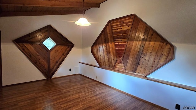 additional living space featuring dark hardwood / wood-style flooring, lofted ceiling with beams, and wooden ceiling