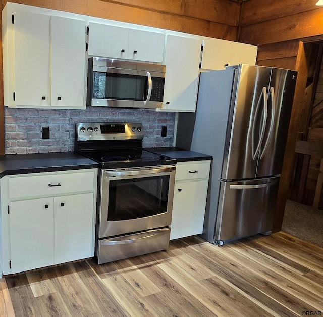 kitchen with white cabinetry, appliances with stainless steel finishes, light hardwood / wood-style floors, and backsplash