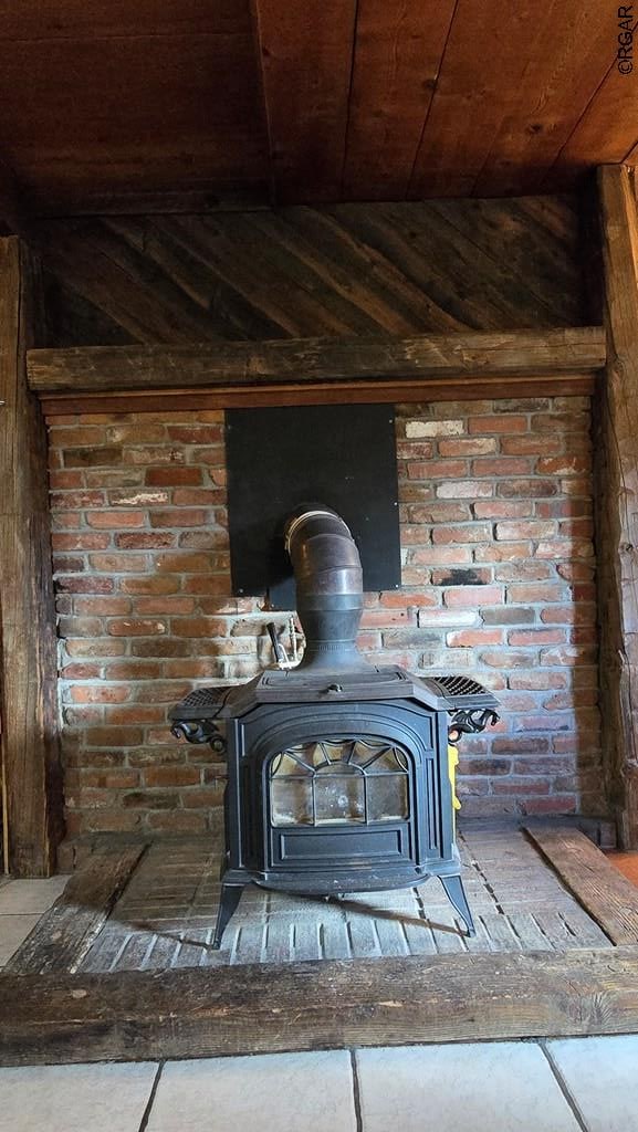 interior details featuring wood ceiling and a wood stove