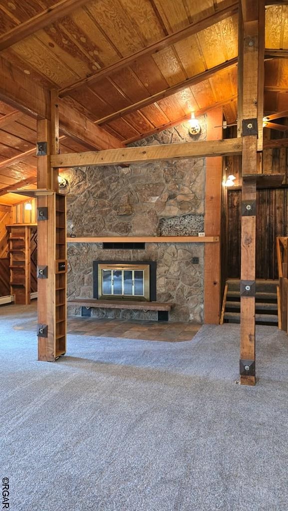 unfurnished living room with wood ceiling, carpet flooring, a fireplace, vaulted ceiling, and wood walls