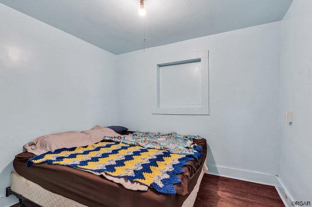 bedroom with dark wood-type flooring