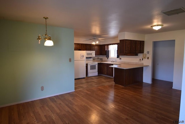 kitchen featuring white appliances, dark wood-type flooring, dark brown cabinets, ceiling fan with notable chandelier, and kitchen peninsula