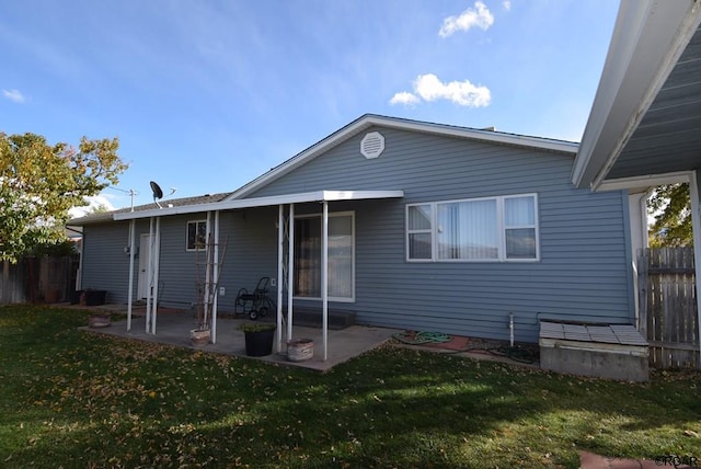 back of property with a yard and a patio