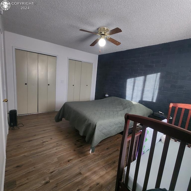 bedroom featuring dark hardwood / wood-style flooring, a textured ceiling, and ceiling fan