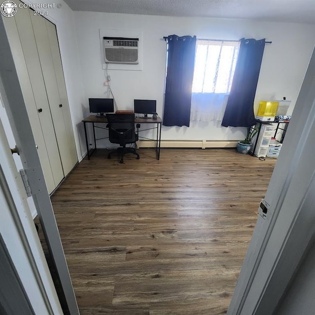 office space featuring dark hardwood / wood-style floors and an AC wall unit