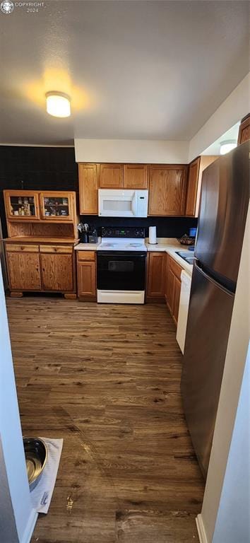 kitchen with stainless steel refrigerator, tasteful backsplash, dark wood-type flooring, and electric range oven