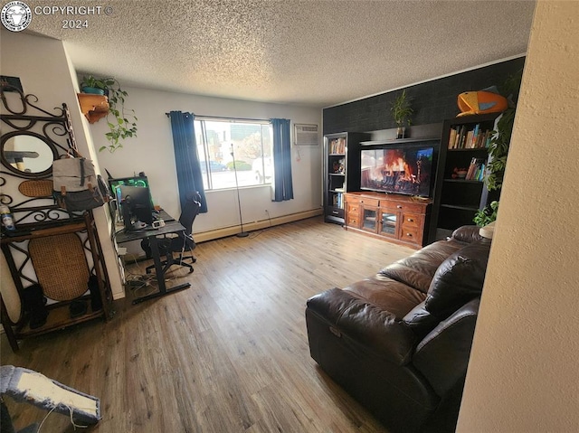 living room featuring hardwood / wood-style floors, a wall mounted air conditioner, a textured ceiling, and baseboard heating