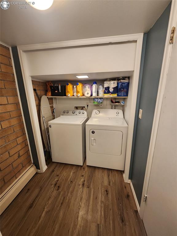 clothes washing area with dark wood-type flooring and washing machine and dryer