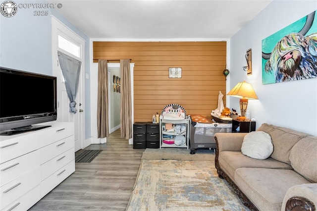 living room with wood walls and light wood-type flooring