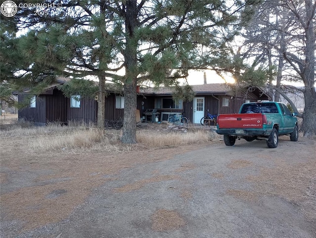 view of front facade with aphalt driveway and board and batten siding