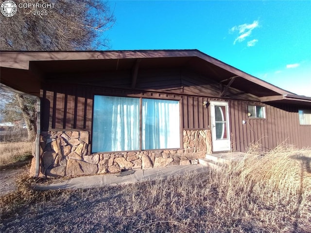 view of side of home with stone siding and board and batten siding