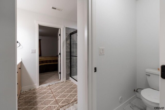 bathroom featuring vanity, an enclosed shower, and toilet