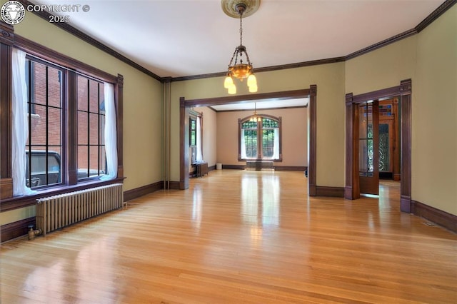 417 Greenwood Ave, Canon City, CO 81212 - unfurnished room featuring radiator heating unit, light wood-style flooring, crown molding, and a chandelier