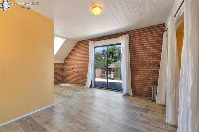 417 Greenwood Ave, Canon City, CO 81212 - bonus room with brick wall, wood finished floors, a skylight, vaulted ceiling, and radiator